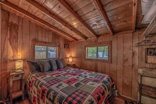 鲁伊多索Knotty Pine: A Cute Ruidoso Classic with a Private Hot Tub!的小木屋内一间卧室,配有一张床