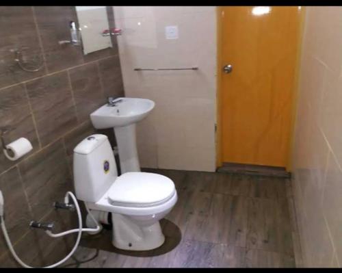 SuriyawewaOctandra Lodge的浴室配有白色卫生间和盥洗盆。