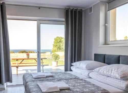 斯瓦讷克Bornholm Apartments的一间卧室设有两张床和大窗户