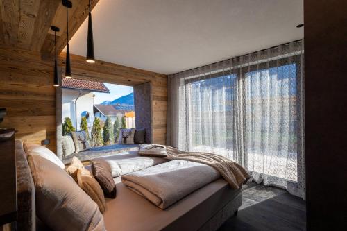 IrschenChalet ORUS - Tirol Kärnten的一间卧室设有一张大床和大窗户