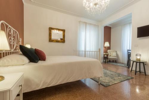 阿尔盖罗Casa dei Liuti的卧室配有白色的床和吊灯。