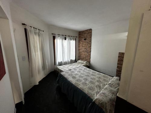 内科切阿Casa hasta 11 personas的一间卧室设有两张床和窗户。