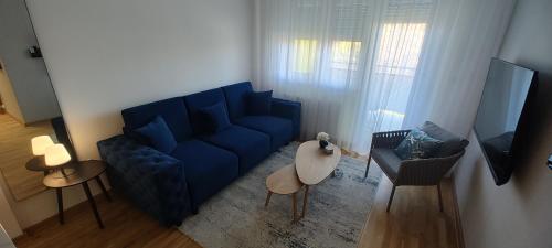 BečejZmaj 94的客厅配有蓝色的沙发和桌子