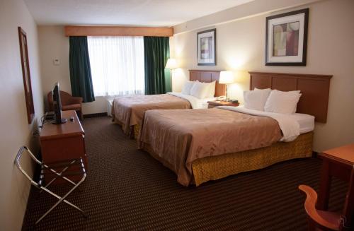 WestlockAll Stay Suites的酒店客房设有两张床和电视。