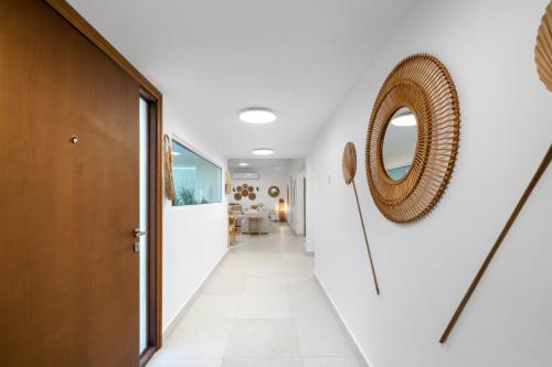 迪拜Jumeirah Three Bedroom House的走廊上设有白色的墙壁和一面镜子