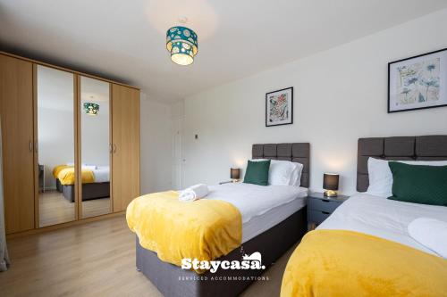 威森肖Bright & Spacious 3 Bedroom Home With Fast Wifi!的一间卧室配有两张床和镜子