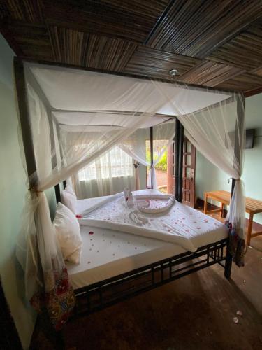 卡拉图Patamu Restaurant & Lodge的一张带天蓬的床