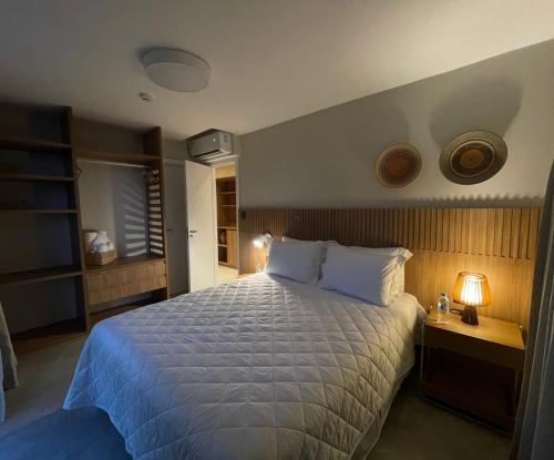 瓜拉久巴Guarajuba Suítes Premium Boutique Hotel的一间卧室配有一张带白色床罩的大床