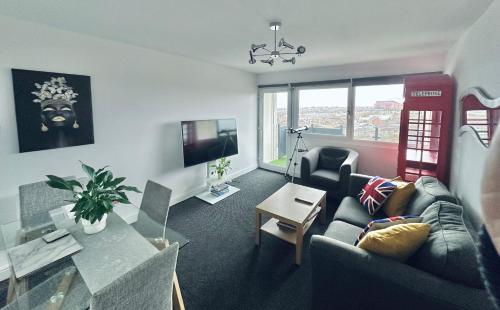 利物浦Unique view of Anfield stadium - Charming 2 bedroom apartment in Liverpool with parking的客厅配有沙发和桌子