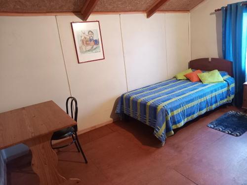 科伊艾科HOSPEDAJE POR TEMPORADA VERANO COYHAIQUE的一间小卧室,配有一张床和一张桌子