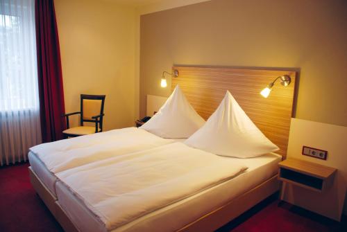 绍尔滕斯慕尼奈克酒店的一张大白色的床,位于酒店客房内
