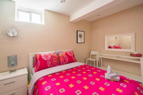 多伦多Charming 2-BDR Apt, Private Entrance, Self Check-in的卧室配有粉红色的床和镜子
