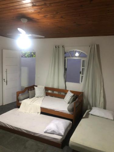布希奥斯Casa de Família com Ar Condicionado, Garagem e Pet friendly的一间卧室设有两张床和窗户。