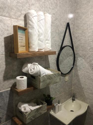 布希奥斯Casa de Família com Ar Condicionado, Garagem e Pet friendly的浴室提供毛巾、水槽和镜子