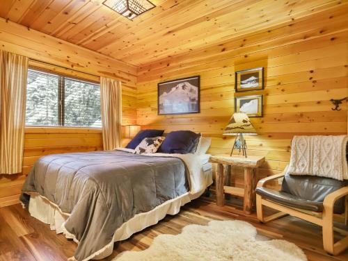 加文门特营Govy Alpine Getaway的小屋内一间卧室配有一张床和一把椅子