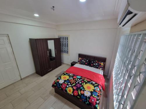 Kwabenyan2 bedrooms Apartment, Hillview of Accra的一间卧室配有一张带红色毯子的床