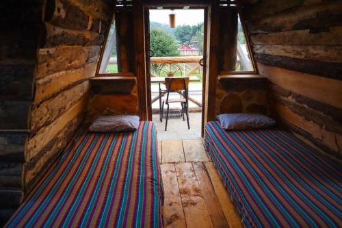 特克潘危地马拉Fuego - Wood Cabin Tecpan (No Wifi, Relax)的带2扇窗户的客房内的2张床