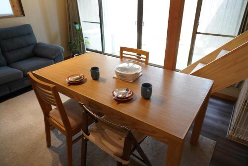 宫津市桜香楽　宮津町家　Sakara Miyazu-Machiya的一张木桌,上面有两杯,一碗