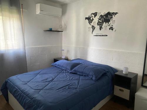 蒙得维的亚Lindo apto Mvd shopping puerto de buceo/pocitos的卧室配有蓝色的床,墙上挂着世界地图