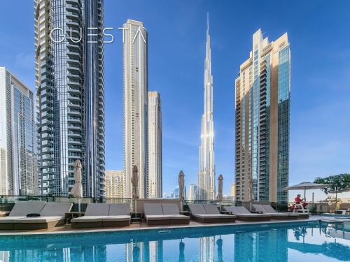 迪拜Act One Act Two by Emaar, Downtown Dubai的城市里一个带躺椅的游泳池