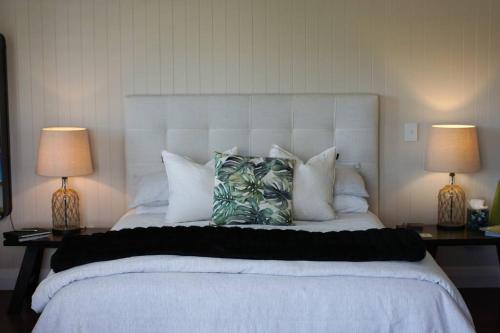 伦威克Luxury cottage with stunning vineyard views的一间卧室配有一张大床、枕头和两盏灯。
