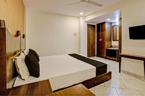 SaravliSuper OYO Flagship Hotel Golden Nest的一间卧室配有一张大床和电视