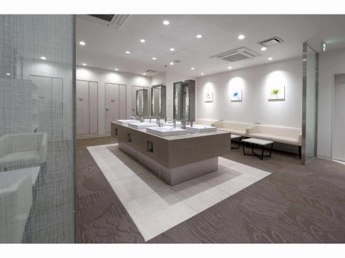 大阪Capsule Hotel J Garden Shin-Osaka的客房内设有带水槽和镜子的浴室
