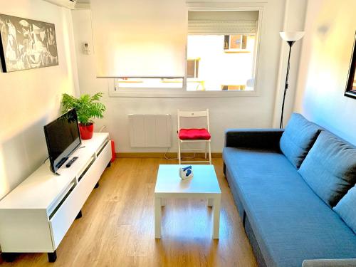 马拉加Ana's Apartment parking gratuito的客厅配有蓝色的沙发和桌子