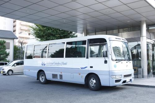 泉佐野關西機場美景花園飯店的停在大楼前的白色巴士