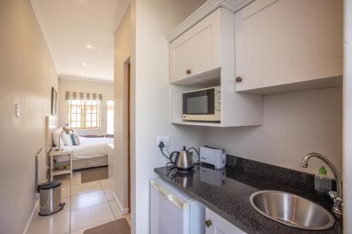 格拉罕镇Lanherne Guest House Bed & Breakfast的一个带水槽的厨房和一张位于客房内的床