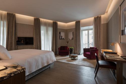 罗马Fendi Private Suites - Small Luxury Hotels of the World的酒店客房,配有一张床、一张桌子和椅子