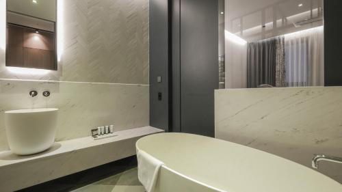 城南市Kynd Hotel的浴室配有白色浴缸和水槽