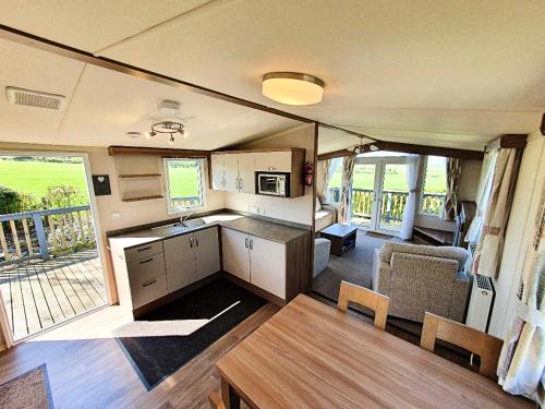 GilcruxLake District Solway View 16 The Beeches Caravan Park的一个带桌子的厨房和用餐区