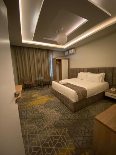 艾卜哈فندق جولدن توليب أبها - GOLDEN TULIP ABHA HOTEl的酒店客房配有一张床铺和一张桌子。