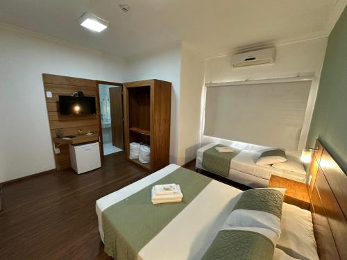 亚瓜龙La Torre Jaguarão的酒店客房设有两张床和电视。