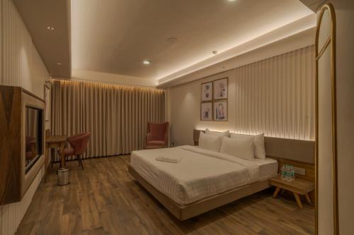 拉杰果德Phoenix Resort的配有一张床和一张书桌的酒店客房