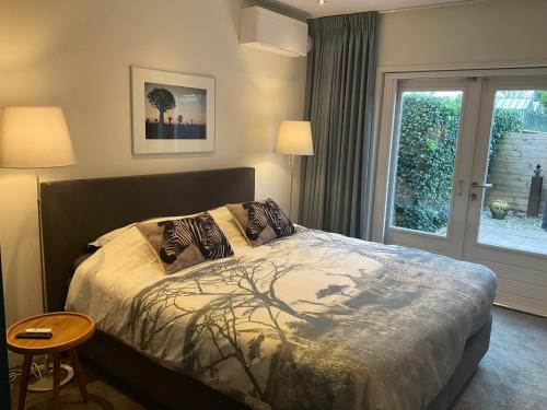 泰沃尔德African Tree的一间卧室配有带两个枕头的床和窗户