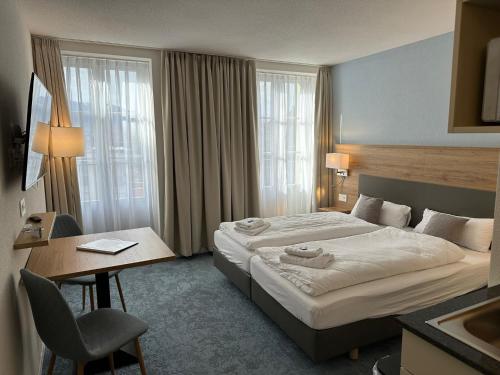因特拉肯Aparthotel Krone - Self Check-In的配有一张床和一张书桌的酒店客房