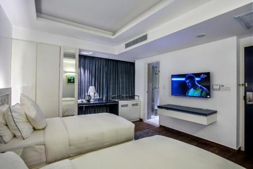 达卡Grace 21 Smart Hotel的一间卧室配有一张床,墙上配有电视