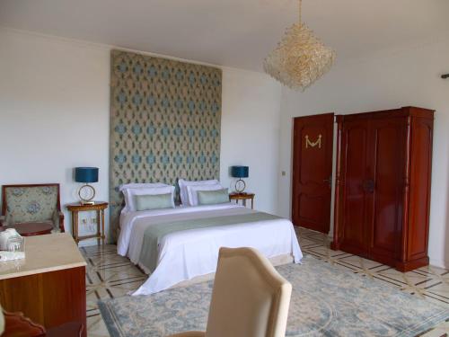 Jasmine Bay Hotel & Spa的卧室配有一张带白色床单和枕头的大床。