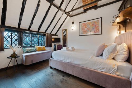 亨利昂泰晤士15th century tiny character cottage-Henley centre的一间卧室配有一张大床和一张沙发