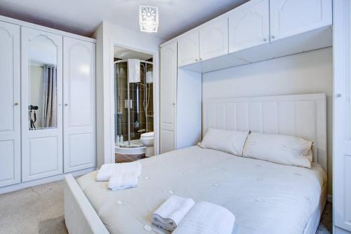 BattlesbridgePass the Keys Spacious 4-Bedroom Home in Benfleet的白色的卧室设有一张大床和一间浴室。