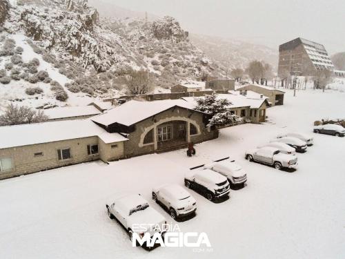洛斯莫莱斯Hotel Termas Lahuen-Có的一群汽车停在一个雪地覆盖的停车场