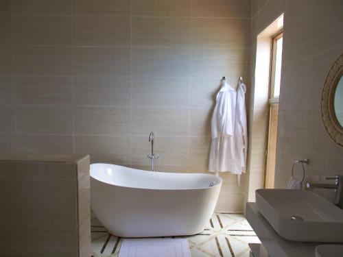 Jasmine Bay Hotel & Spa的浴室配有白色浴缸及水槽