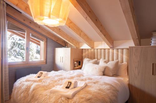 韦尔比耶La Ruinette- Stylish 4-bed, Centre Of Verbier的一间卧室配有一张大床和两条毛巾