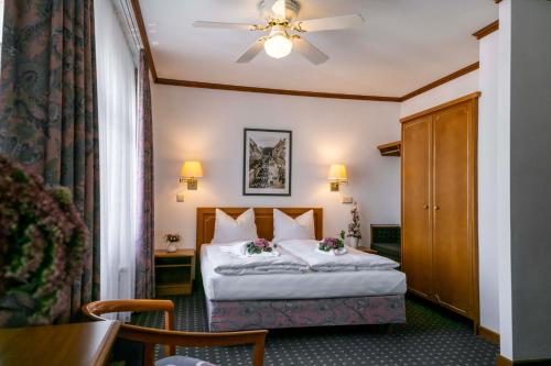 弗赖贝格阿勒卡特酒店的酒店客房配有一张床和吊扇。