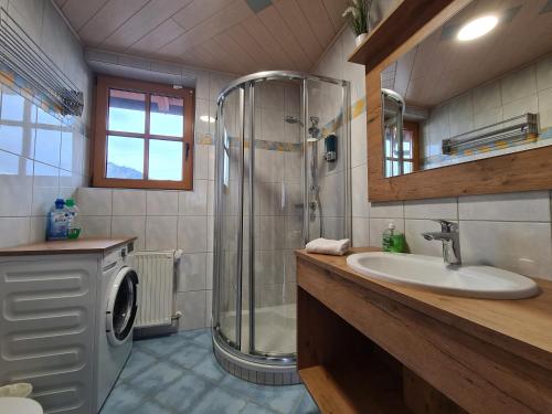 恩斯河谷艾根Ferienwohnung Schupfer的带淋浴、盥洗盆和洗衣机的浴室