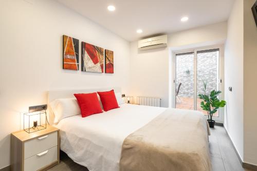 滨海普雷米亚Luxury Beach Apartment, next to the sea的卧室配有带红色枕头的大型白色床