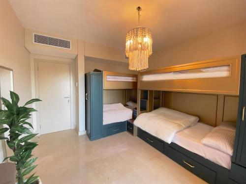 赫尔格达Glamorous 2BR/ Free Beach & Pool Access @ Mangroovy, El Gouna的一间卧室设有两张双层床和吊灯。