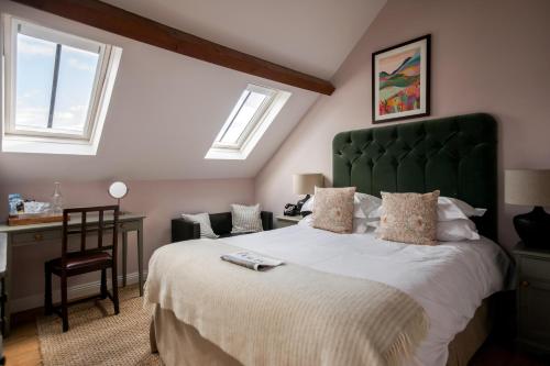 欣登小羊旅馆的一间卧室配有一张大床和绿色床头板